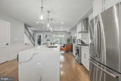 a large white kitchen with stainless steel appliances