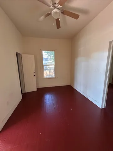 an empty room with a window and wooden floor