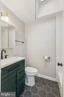 a bathroom with a sink mirror and toilet
