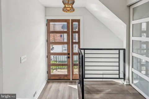 a view of a hallway with entryway and chandelier