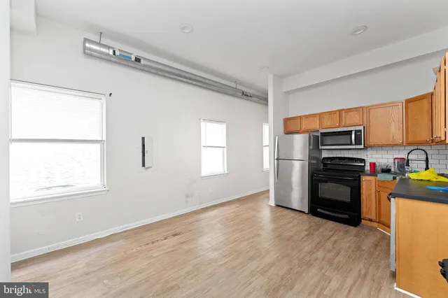 a kitchen with granite countertop a refrigerator and a stove top oven