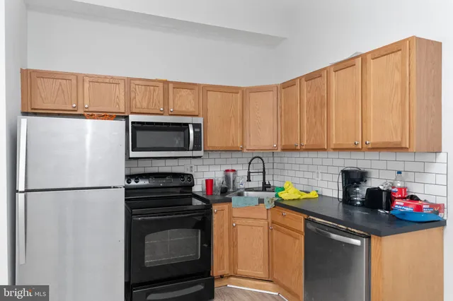 a kitchen with stainless steel appliances granite countertop a refrigerator sink and stove