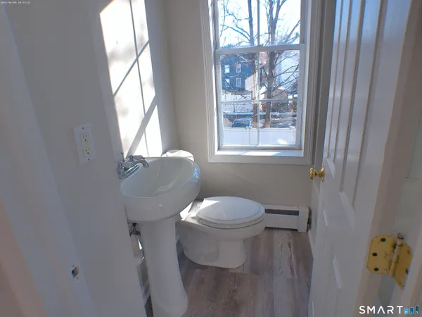 a white toilet sitting next to a window in a bathroom