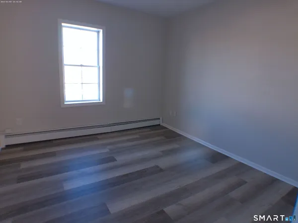 a view of a room that has wooden floor and windows in it