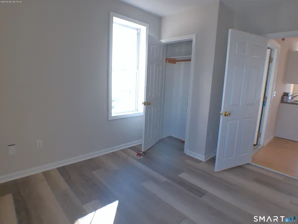 an empty room with wooden floor and window