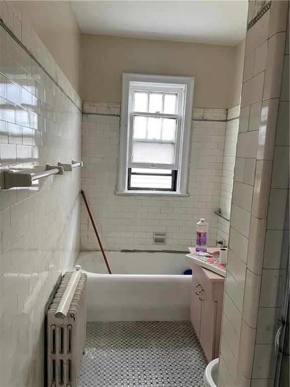1423 Schenectady Avenue Brooklyn, NY 11203 - Photo 13 of 45 a bathroom with a bathtub a window and a shower