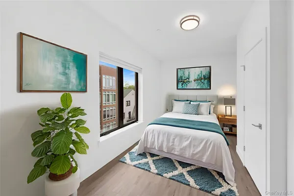 a bedroom with a bed potted plant and a window