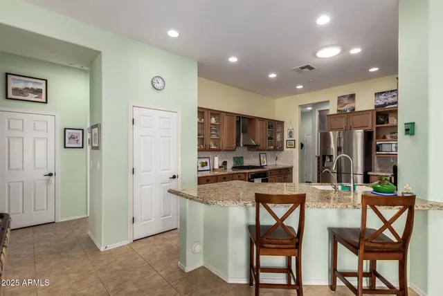 a dining room with furniture a chandelier and kitchen view