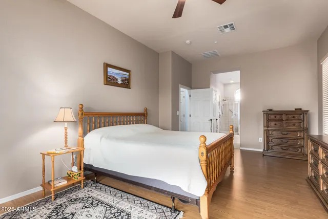 a view of a backyard with table and chairs potted plants and large tree