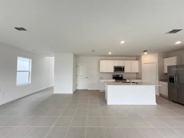 a kitchen with a sink a counter top space stainless steel appliances and cabinets