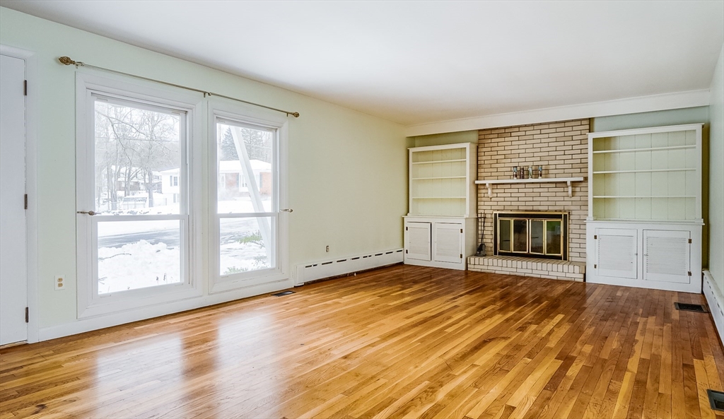 9 Cloverleaf Road Leominster, MA 01453 - Photo 12 of 19 a view of empty room with wooden floor and fireplace
