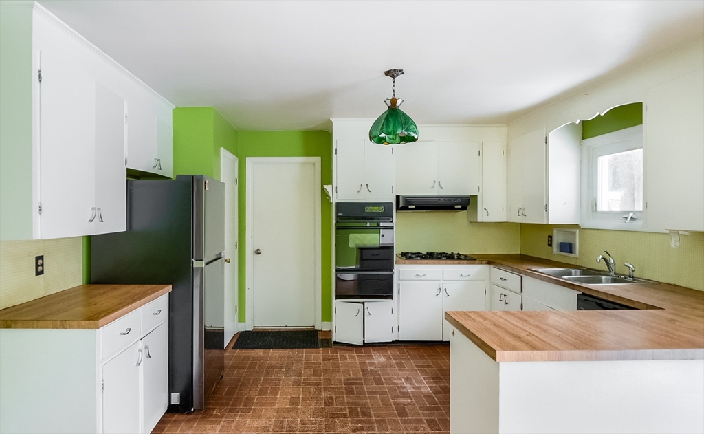9 Cloverleaf Road Leominster, MA 01453 - Photo 8 of 19 a kitchen with a refrigerator a sink and wooden cabinets