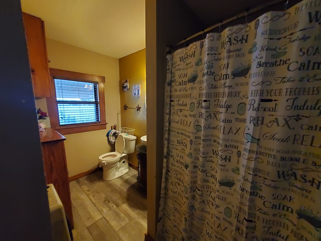 208 Houston Street Menard, TX 76859 - Photo 11 of 17 a bathroom with a toilet and a shower curtain