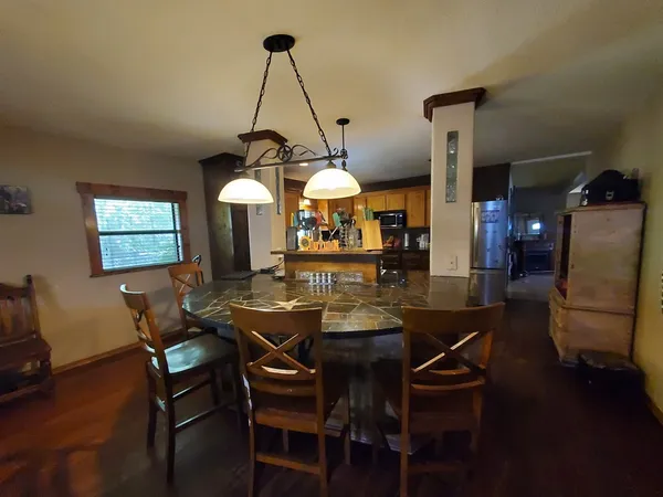 a view of a dining room and a livingroom with furniture wooden floor a chandelier