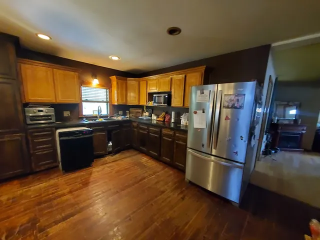 a kitchen with wooden floors appliances and cabinets
