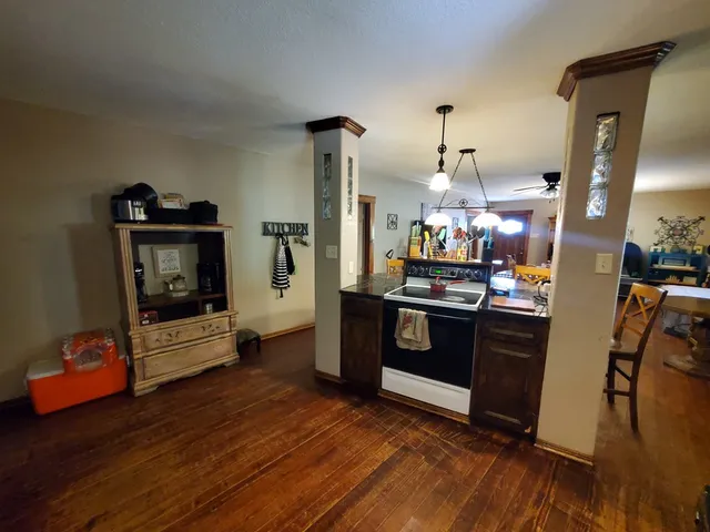 a kitchen with granite countertop a refrigerator stove and wooden floor