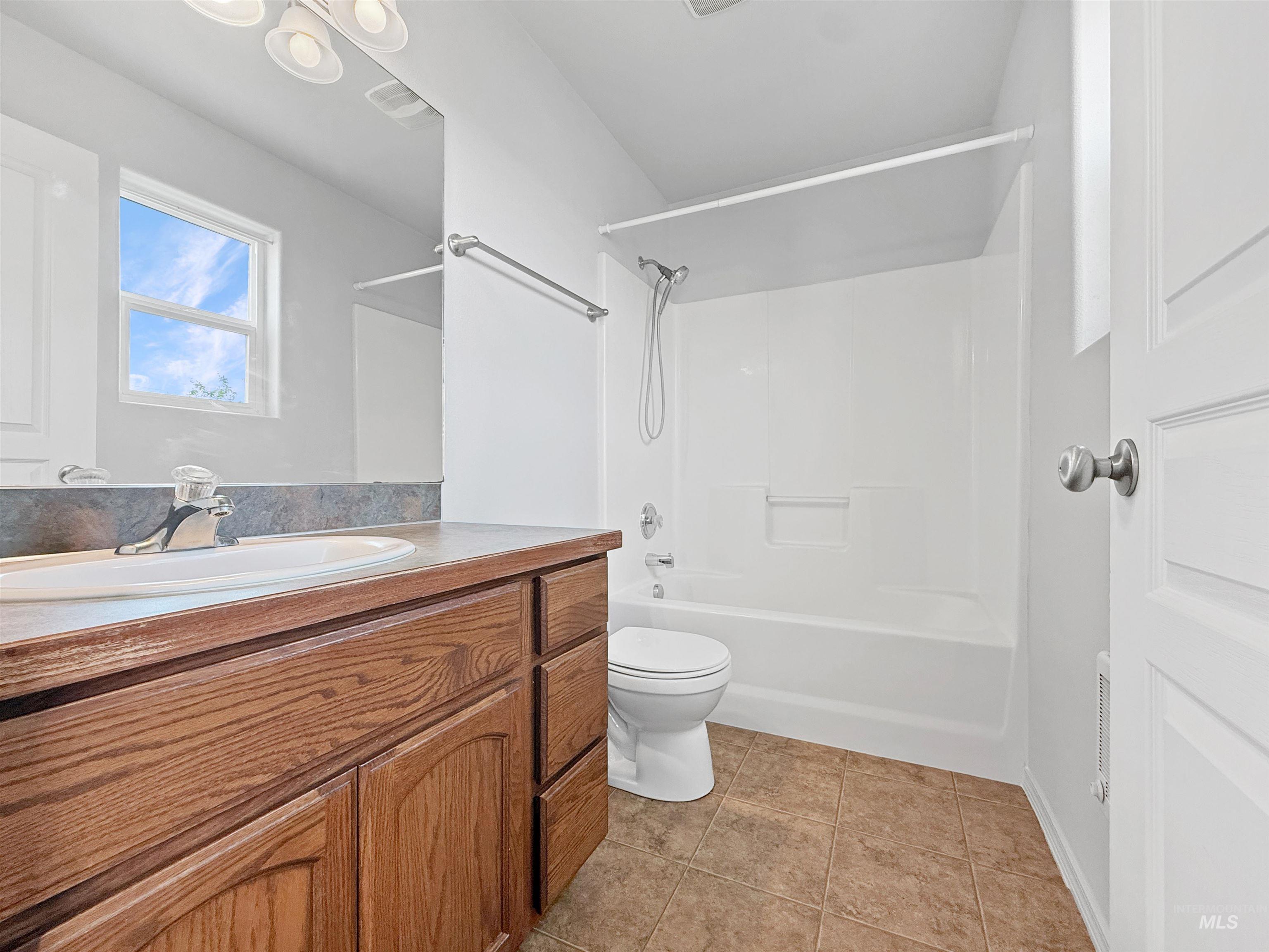 1354 Bristol Road Moscow, ID 83843 - Photo 10 of 19 Bathroom featuring a wood-finish vanity with an integrated sink, a large mirror, and overhead lighting