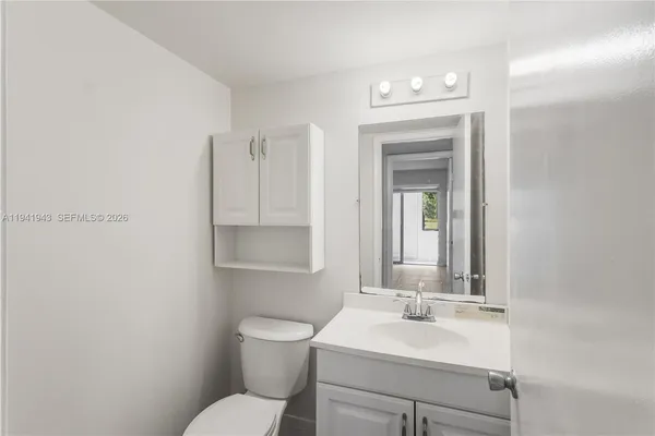 a bathroom with a sink vanity mirror and toilet
