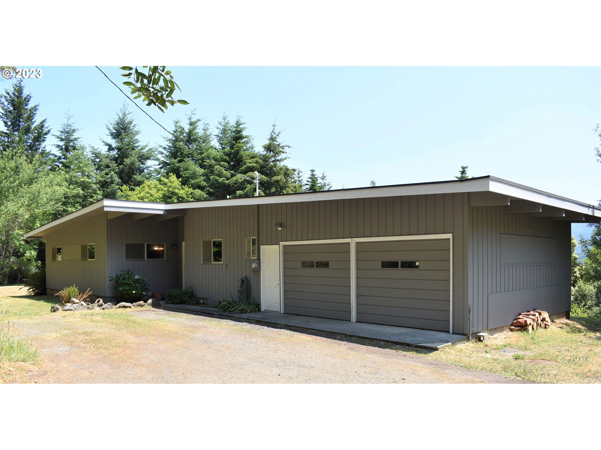95144 Marchmont Road Gold Beach, OR 97444 - Photo 2 of 34 a black house with a outdoor space