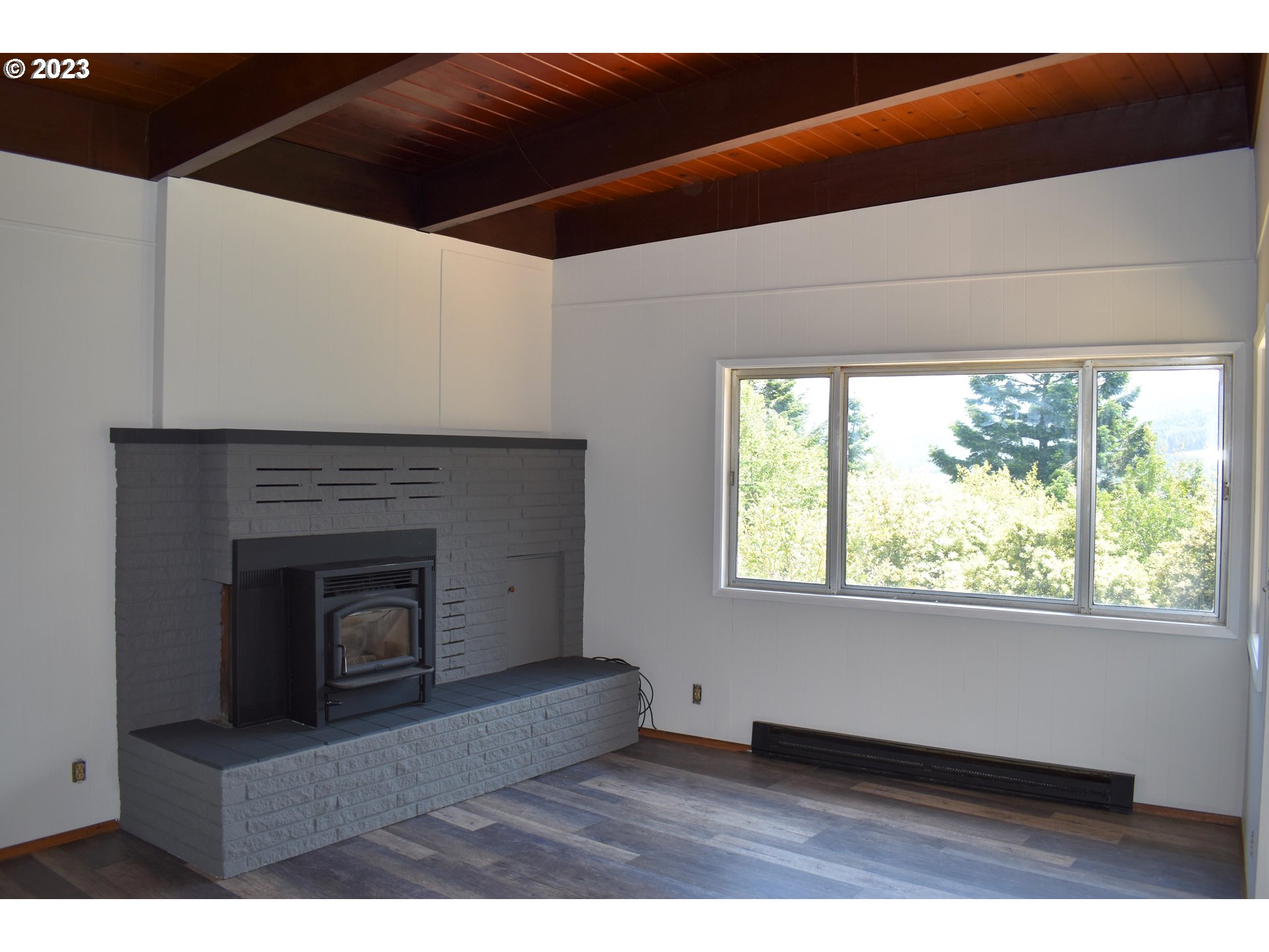 95144 Marchmont Road Gold Beach, OR 97444 - Photo 7 of 34 a living room with a fireplace and a floor