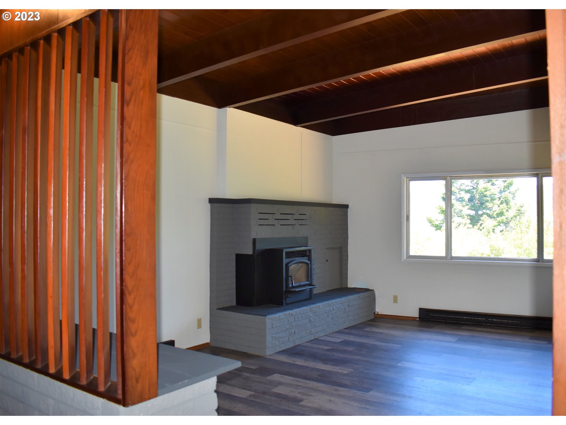 95144 Marchmont Road Gold Beach, OR 97444 - Photo 8 of 34 a view of an empty room with wooden floor fireplace and a window