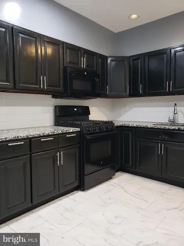 a kitchen with granite countertop a cabinets and steel appliances