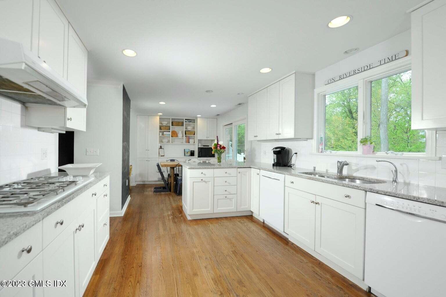 16 Crescent Road Riverside, CT 06878 - Photo 7 of 33 a large kitchen with stainless steel appliances kitchen island granite countertop a stove a sink dishwasher and white cabinets with wooden floor
