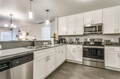 a kitchen with stainless steel appliances granite countertop a sink a stove a microwave and cabinets