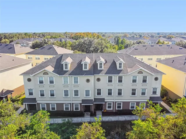 a living room with furniture a large window and potted plants