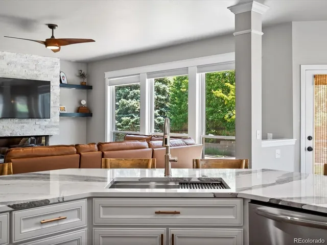 a view of kitchen with granite countertop stainless steel appliances and windows