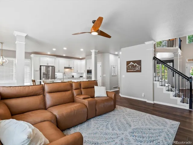 a living room with furniture and a ceiling fan