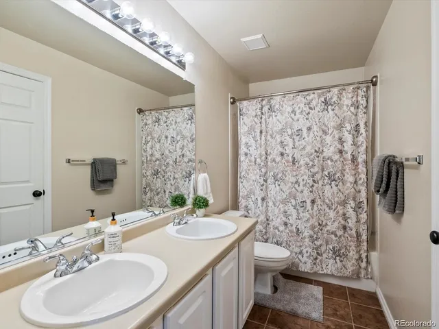 a bathroom with a double vanity sink toilet and shower