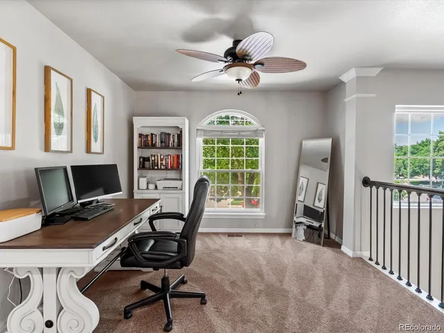 a view of a workspace with furniture and a window