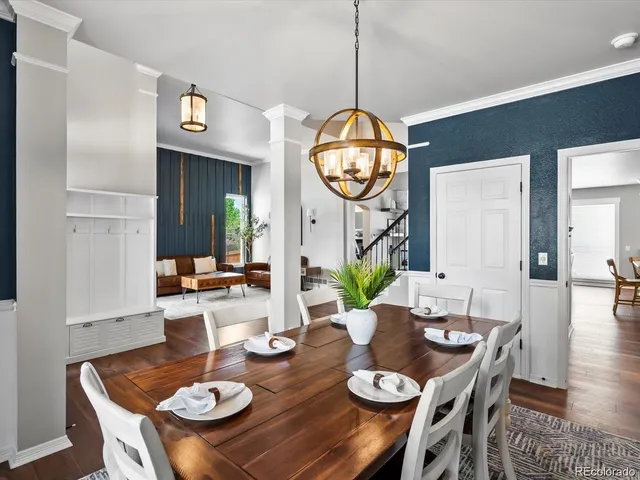 a view of a dining room and livingroom with furniture wooden floor a chandelier