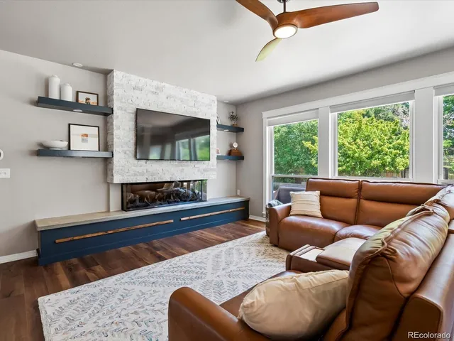 a living room with furniture a flat screen tv and a fireplace