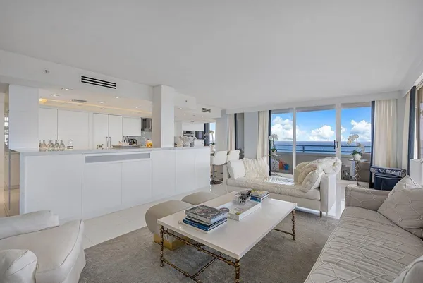 a large white kitchen with a large counter top and stainless steel appliances
