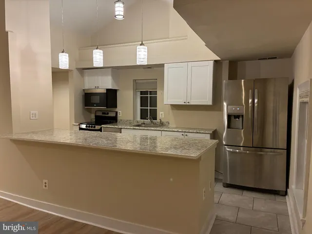 a kitchen with stainless steel appliances granite countertop a refrigerator sink and microwave