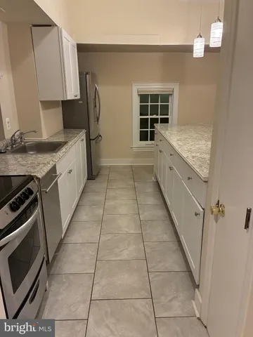 a kitchen with a sink a stove and a window