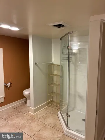 a bathroom with a granite countertop shower a toilet and a sink