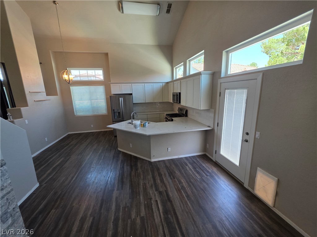 2275 Ramsgate Drive Henderson, NV 89074 - Photo 34 of 84 A contemporary kitchen and living area with lofty ceilings and rich wood flooring offers a harmonious gathering space.
