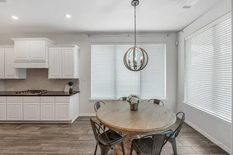 a very nice looking kitchen with a kitchen island a stove a table and chairs