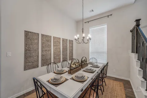 a view of a dining room with furniture a chandelier and wooden floor