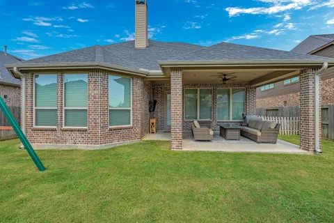 a view of a house with backyard porch and sitting area