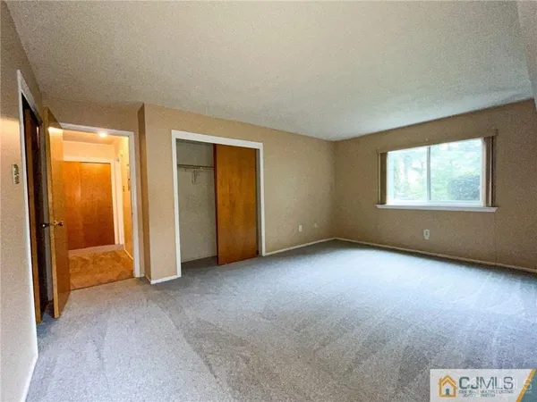 an empty room with windows and closet