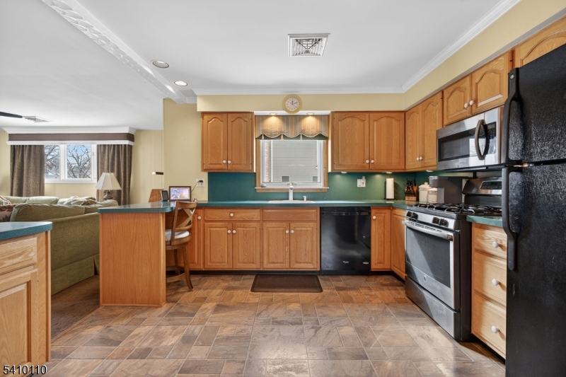 710 West Elm Street Linden, NJ 07036 - Photo 9 of 24 a kitchen with stainless steel appliances granite countertop a stove top oven a sink a counter space and cabinets