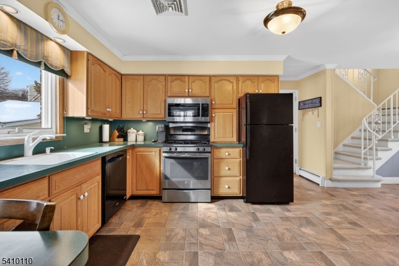 710 West Elm Street Linden, NJ 07036 - Photo 10 of 24 a kitchen with a refrigerator sink and cabinets