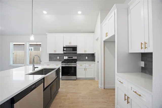 a kitchen with stainless steel appliances a stove sink and refrigerator