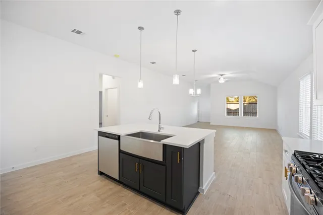 a view of a kitchen island a sink a window and appliances
