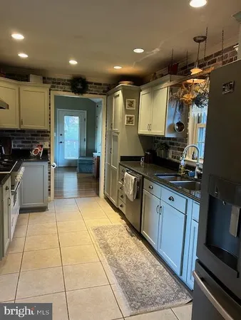 a large kitchen with stainless steel appliances granite countertop a stove a sink and a microwave