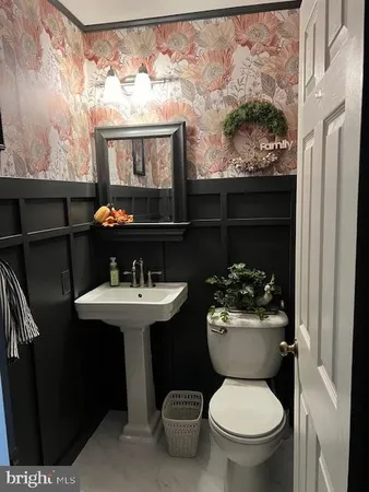 a bathroom with a sink toilet and a mirror